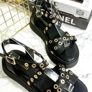 Sandalia de tiras negras con tachuelas doradas.