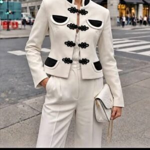 chaqueta blanca con pasamanería en negra.